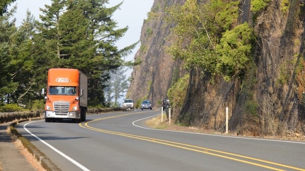 Nehalem, OR, USA - September 21, 2022; Orange truck travelling southbound through curves on Pacific Coast Highway US 101 in Oregon; Shutterstock ID 2206771449; purchase_order: -; job: -; client: -; other: -
